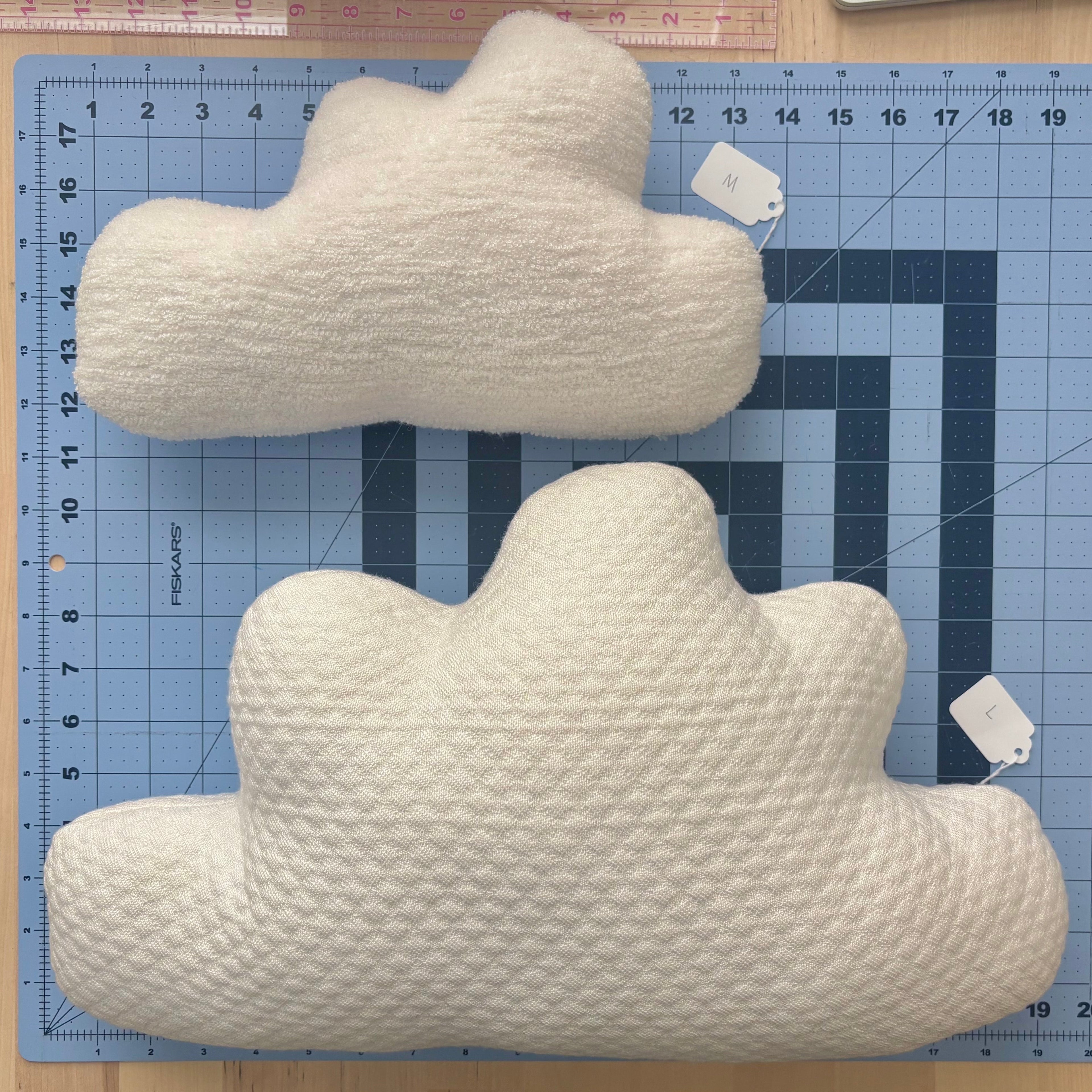 One each of a medium and large Cloud Pillow on a blue cutting mat for scale.