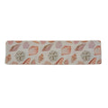 Off-white fabric bookmark with a pink seashell pattern on a white background.