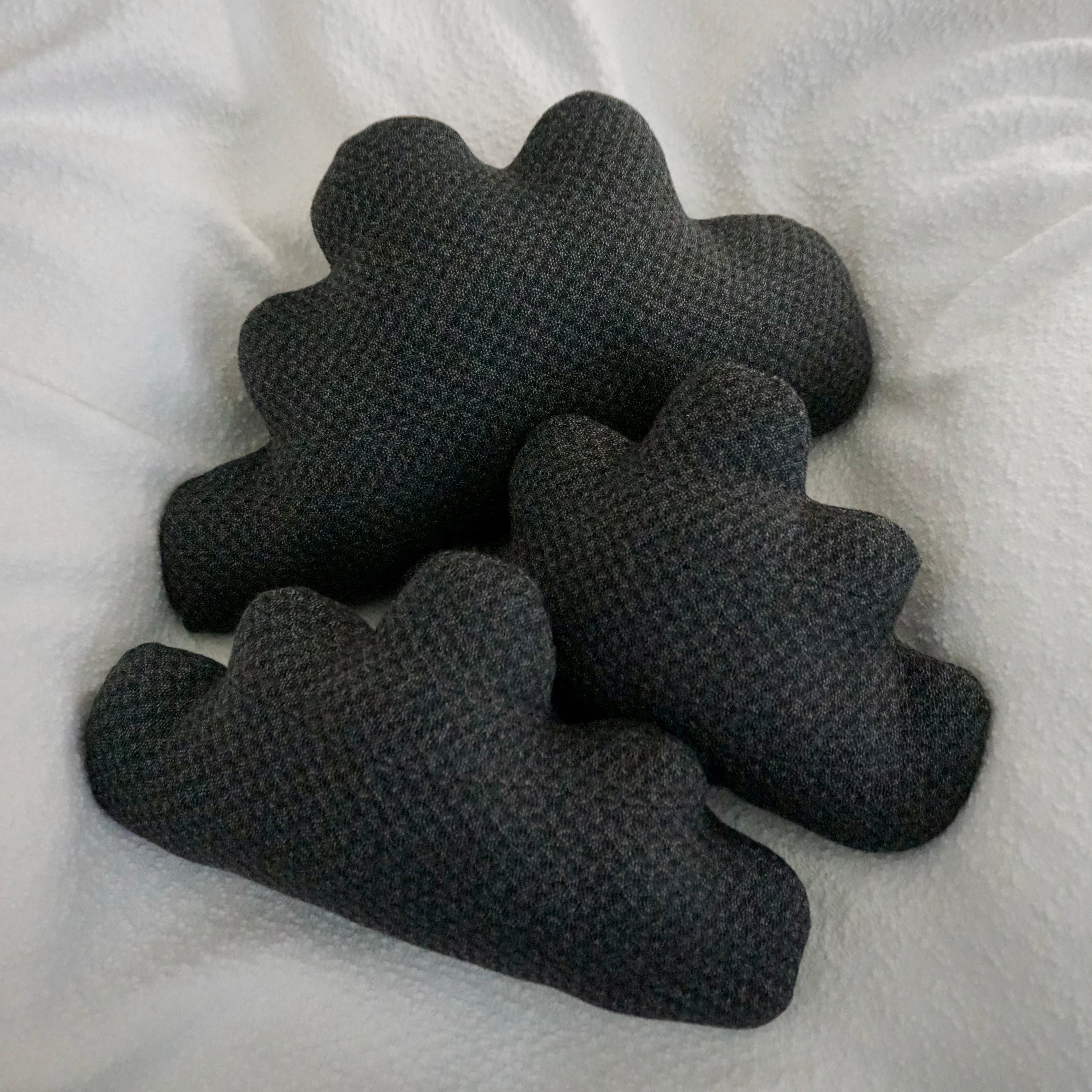 Three large Storm Cloud Pillows arranged together on a textured white blanket.