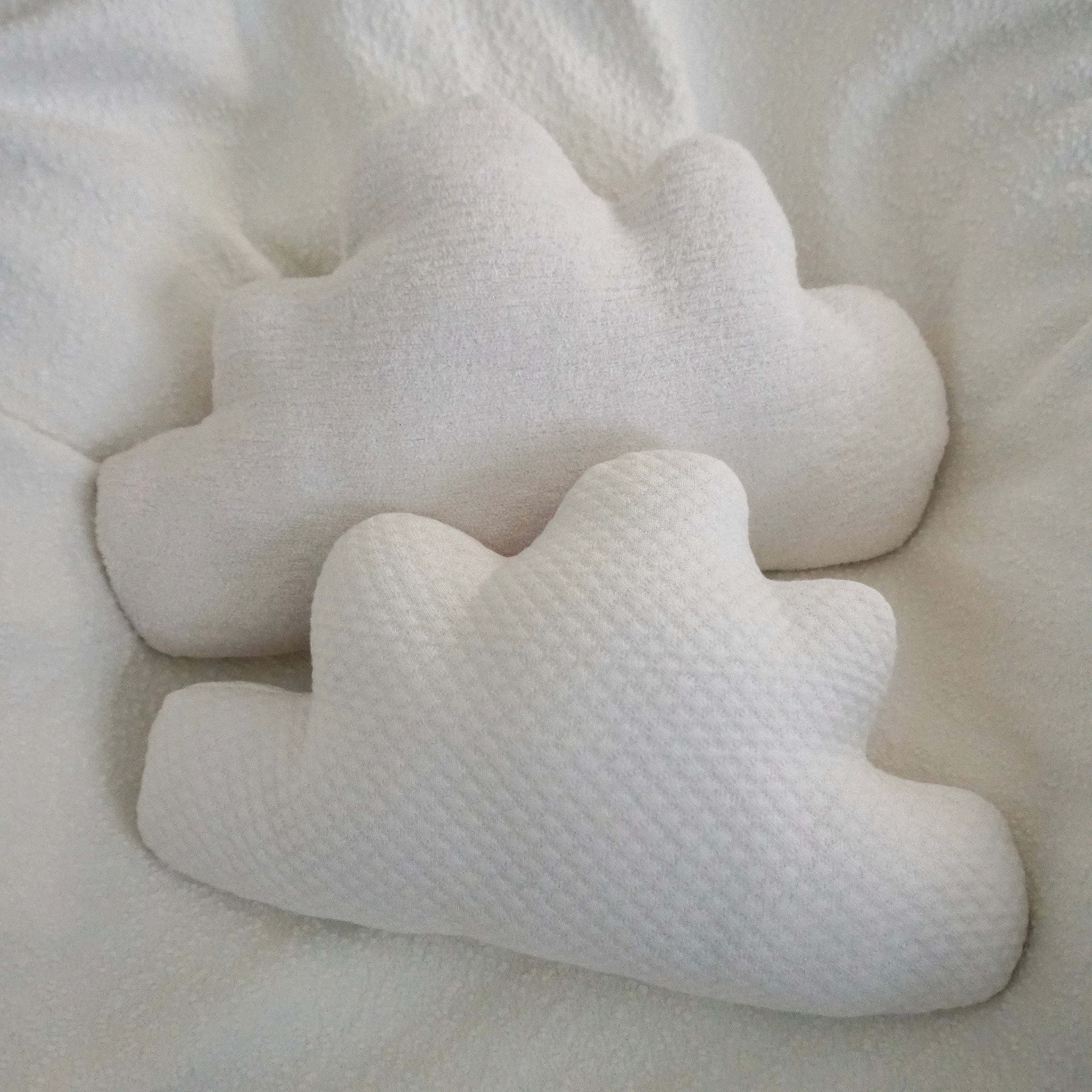 Two large Cloud Pillows in a chair with a white boucle blanket draped over it.